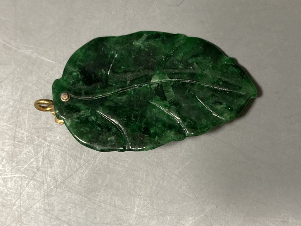 A yellow metal mounted mottled green jade leaf pendant, overall 58mm, gross 11.1 grams.